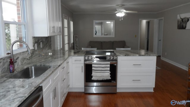 kitchen with a sink, white cabinetry, appliances with stainless steel finishes, a peninsula, and dark wood finished floors