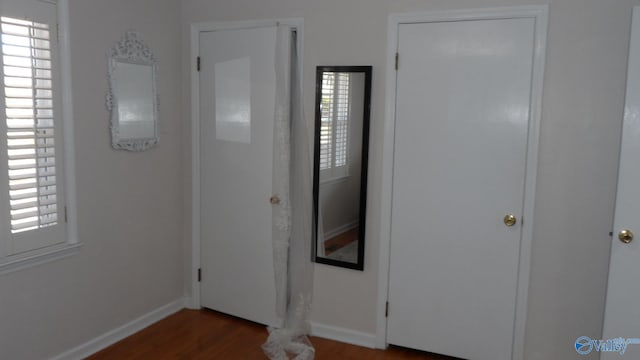 foyer entrance featuring baseboards and wood finished floors