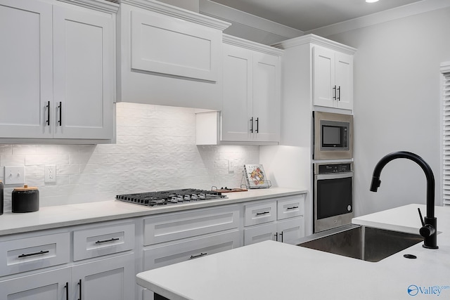 kitchen featuring a sink, light countertops, stainless steel appliances, and white cabinetry