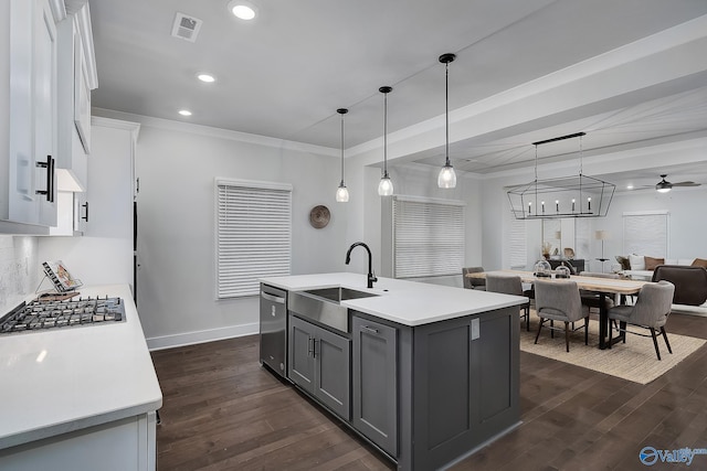 kitchen with dark wood-style flooring, appliances with stainless steel finishes, a sink, light countertops, and gray cabinetry