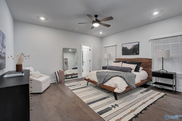 bedroom with baseboards, a ceiling fan, wood finished floors, and visible vents