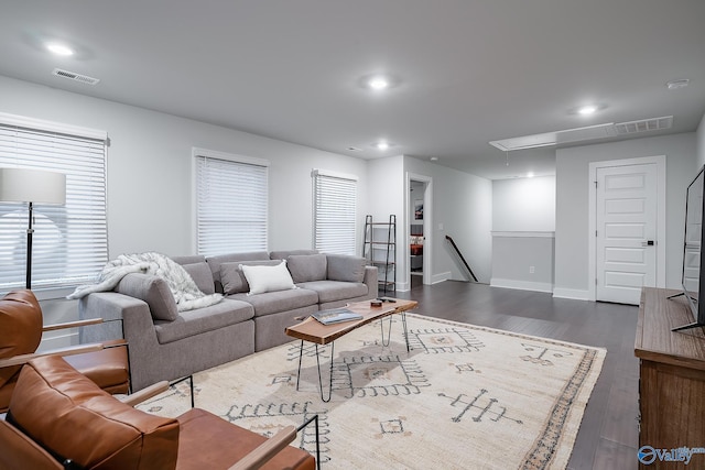 living room with visible vents, dark wood-style floors, a wealth of natural light, and attic access