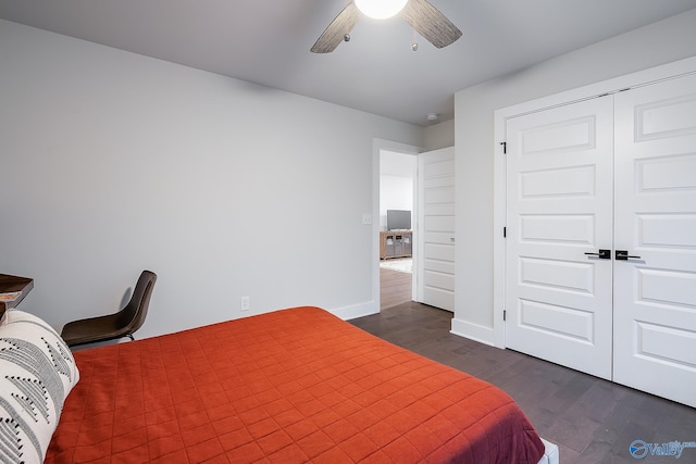 bedroom featuring a ceiling fan, baseboards, dark wood finished floors, and a closet