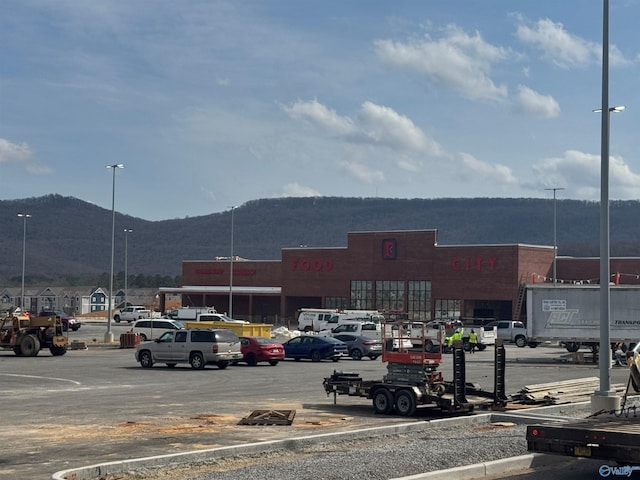 view of building exterior featuring uncovered parking and a mountain view