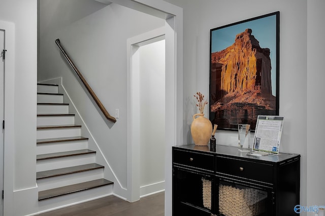 hall with baseboards, stairs, and dark wood-style floors
