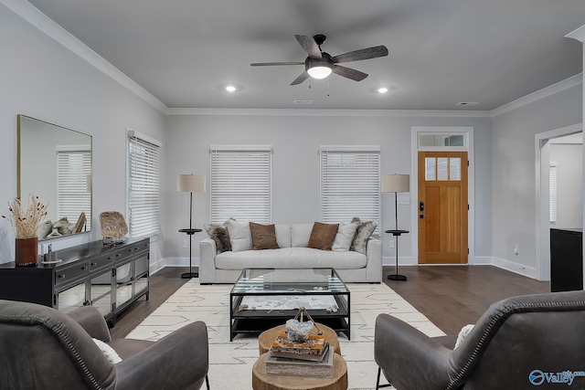 living room featuring baseboards, ornamental molding, a ceiling fan, and dark wood-style flooring