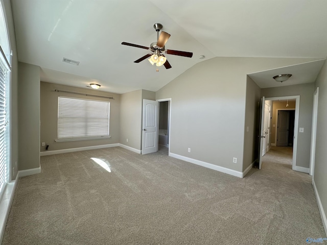 unfurnished bedroom with lofted ceiling, light colored carpet, visible vents, baseboards, and attic access