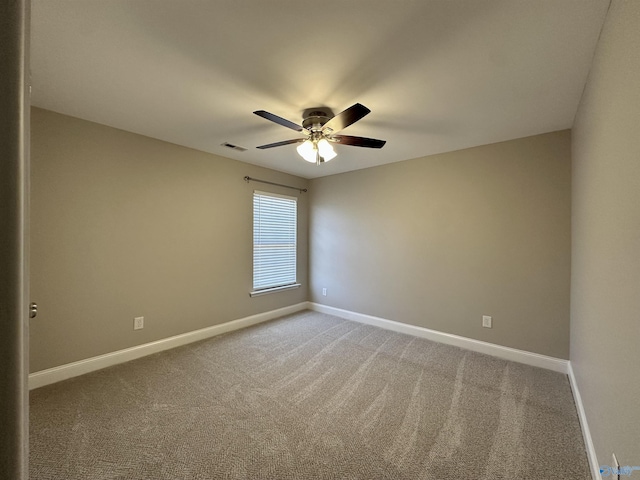 empty room with light carpet, a ceiling fan, visible vents, and baseboards