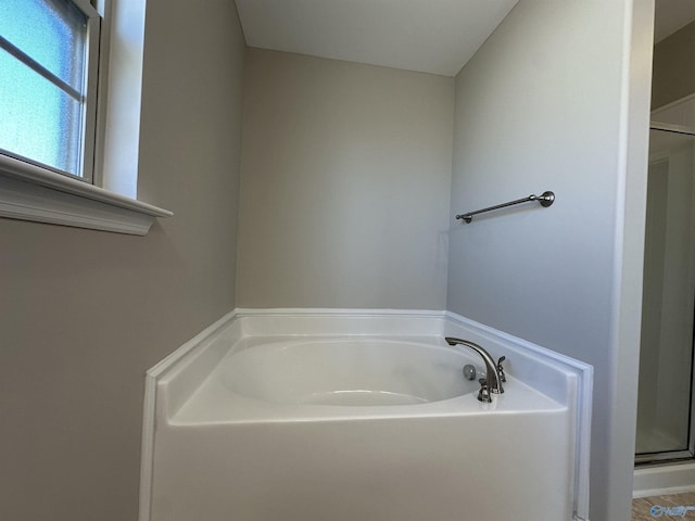 bathroom featuring a stall shower and a garden tub