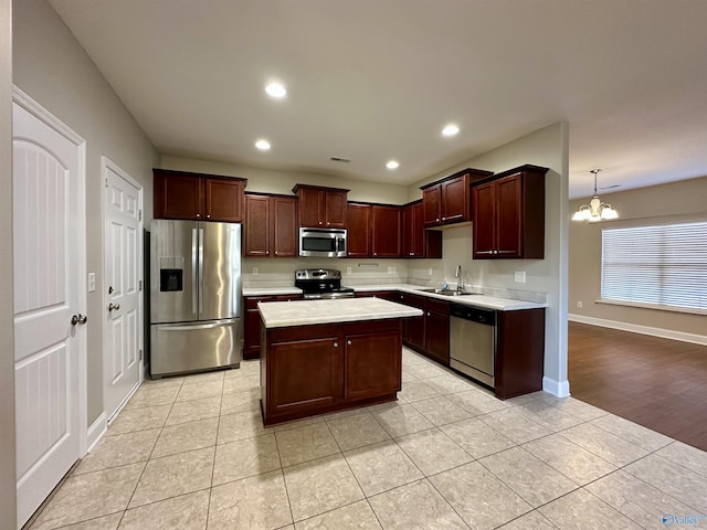 kitchen with light tile patterned floors, appliances with stainless steel finishes, an inviting chandelier, light countertops, and recessed lighting