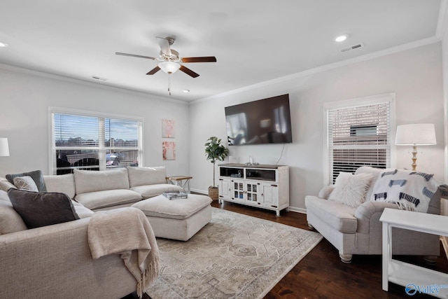 living area featuring dark wood-type flooring, visible vents, and crown molding