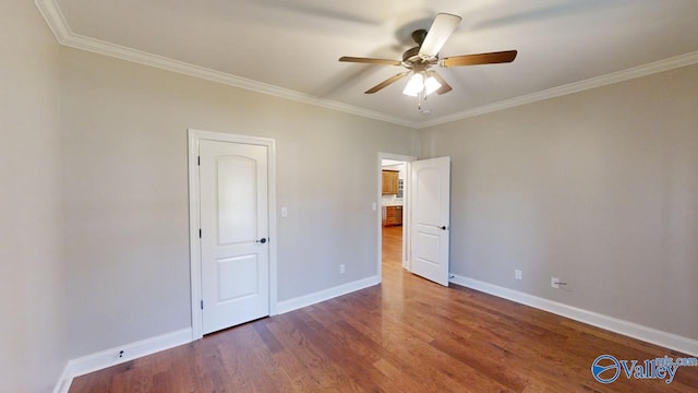 unfurnished bedroom with ceiling fan, dark wood-type flooring, and crown molding