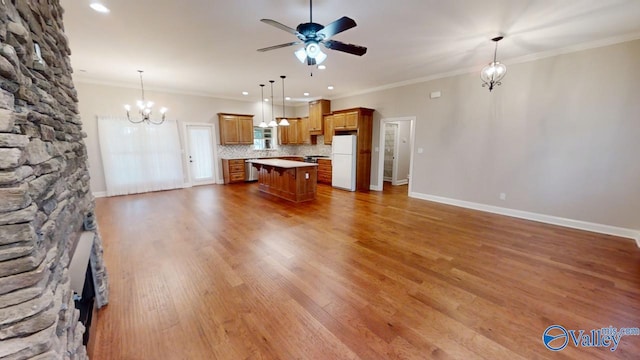 unfurnished living room with ornamental molding, ceiling fan with notable chandelier, and hardwood / wood-style flooring