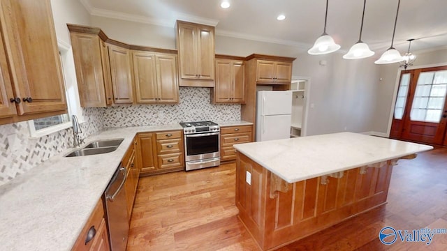 kitchen featuring appliances with stainless steel finishes, tasteful backsplash, light wood-type flooring, a center island, and sink