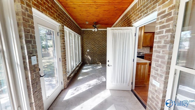 unfurnished sunroom with wood ceiling and ceiling fan