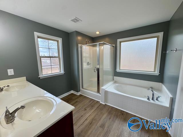 bathroom featuring vanity, hardwood / wood-style flooring, and shower with separate bathtub