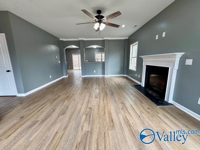 unfurnished living room featuring ceiling fan and light hardwood / wood-style flooring