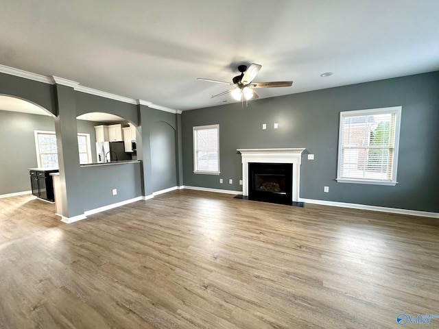 unfurnished living room featuring ceiling fan and hardwood / wood-style floors