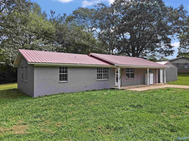 view of front of house featuring stucco siding, a patio area, metal roof, and a front yard