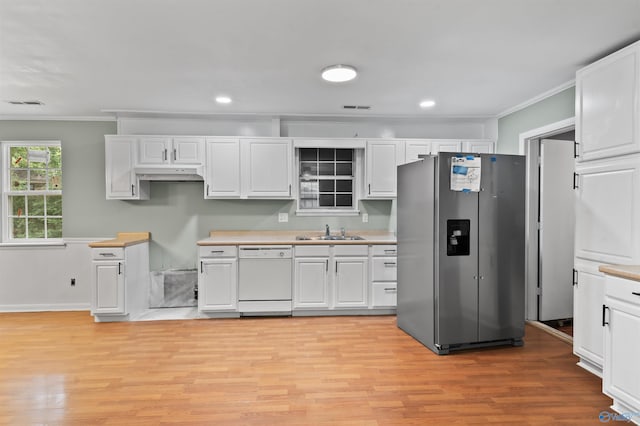 kitchen featuring light countertops, stainless steel fridge, white dishwasher, and a sink