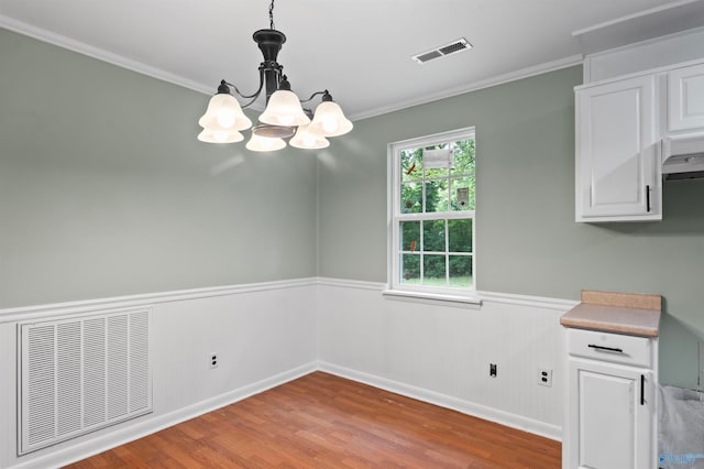 unfurnished dining area with hardwood / wood-style floors, an inviting chandelier, and a healthy amount of sunlight