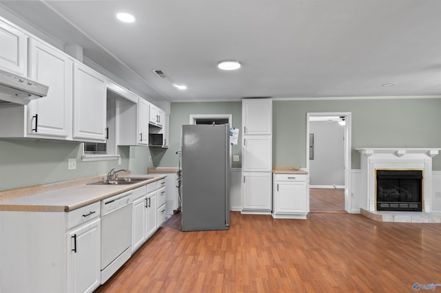 kitchen featuring light countertops, freestanding refrigerator, white cabinets, a sink, and dishwasher