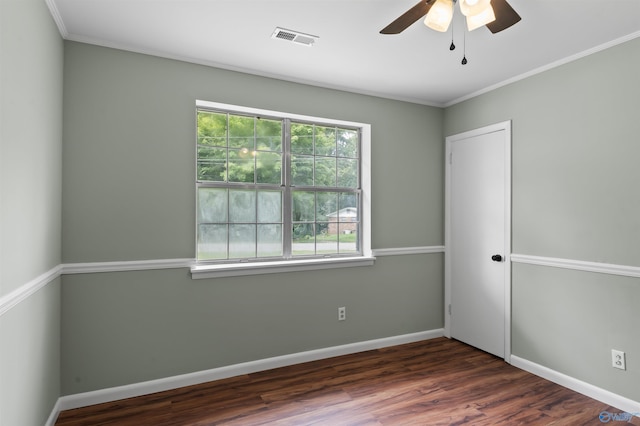 spare room featuring baseboards, visible vents, ceiling fan, ornamental molding, and dark wood-type flooring