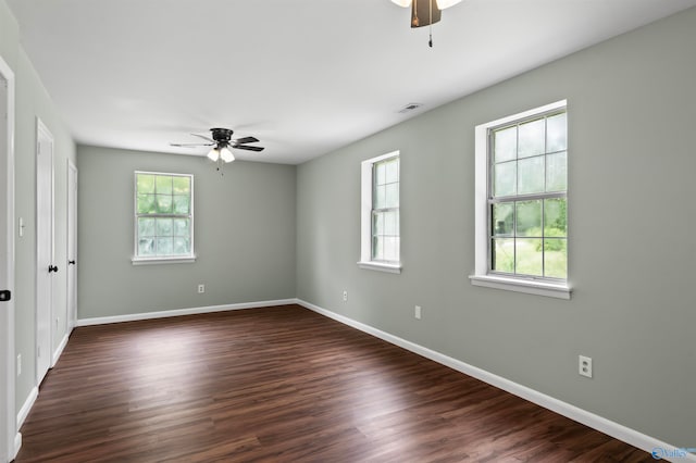 empty room with ceiling fan, plenty of natural light, and hardwood / wood-style flooring