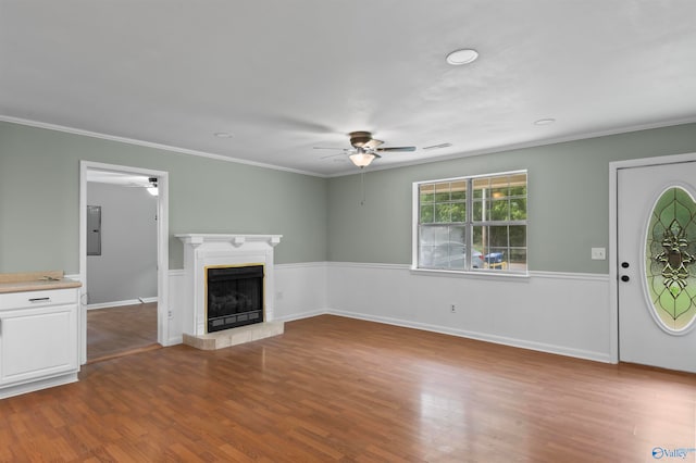 unfurnished living room featuring hardwood / wood-style flooring, crown molding, electric panel, and ceiling fan