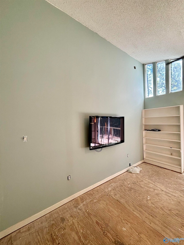 interior space with a textured ceiling and hardwood / wood-style flooring