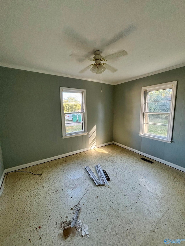 empty room featuring ceiling fan and crown molding