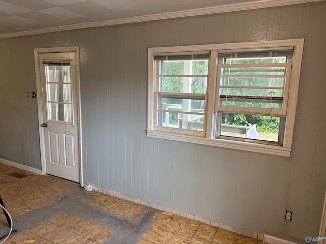 unfurnished room with wooden walls and crown molding