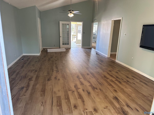 unfurnished living room with dark hardwood / wood-style floors, ceiling fan, and vaulted ceiling