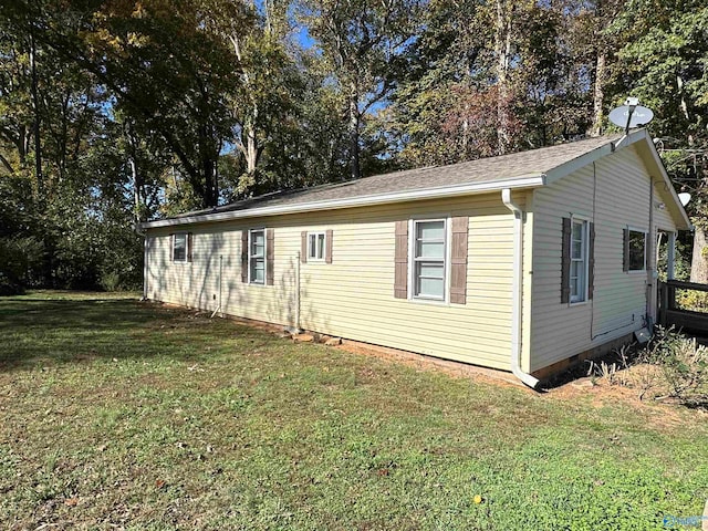 view of side of home with a yard