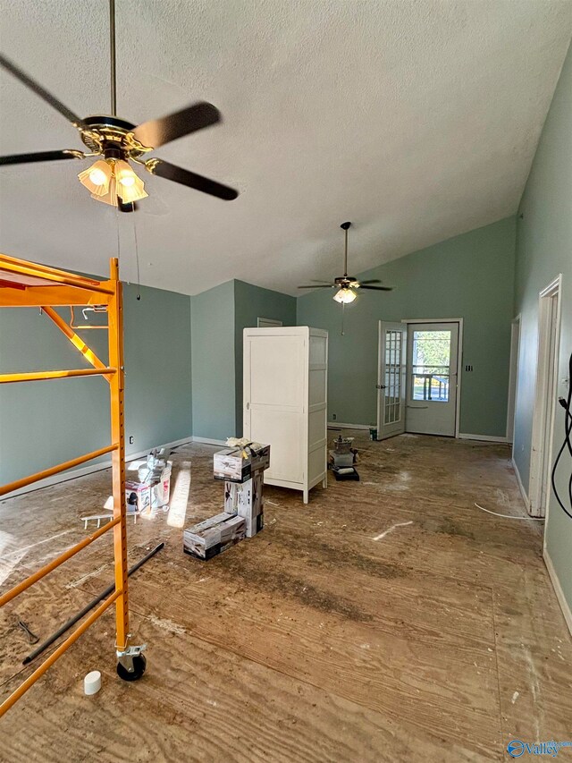 interior space with ceiling fan, wood-type flooring, a textured ceiling, and vaulted ceiling