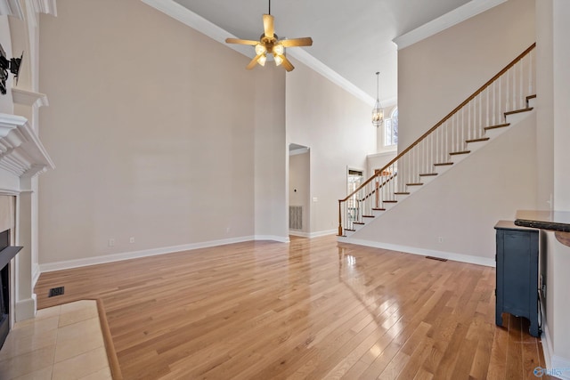 living room with baseboards, visible vents, light wood-style flooring, stairway, and a fireplace