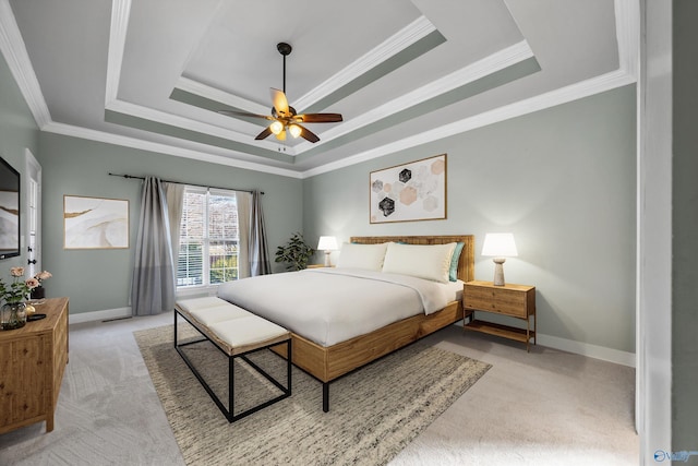 bedroom featuring ornamental molding, a tray ceiling, light carpet, and baseboards