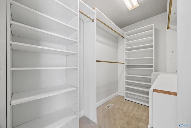 spacious closet featuring light carpet and visible vents