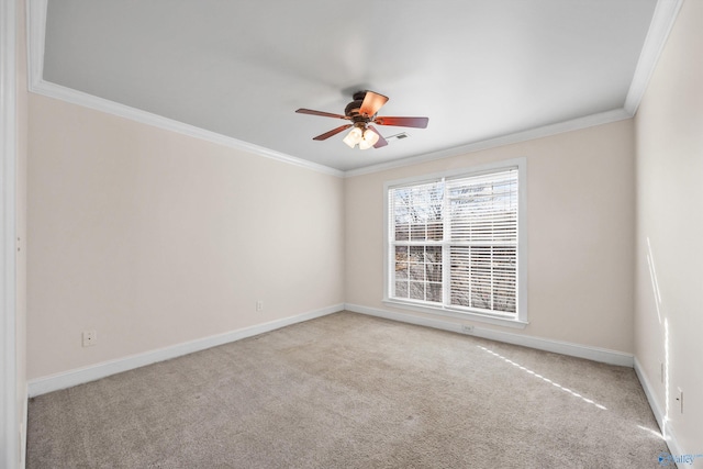 empty room with carpet floors, crown molding, visible vents, ceiling fan, and baseboards