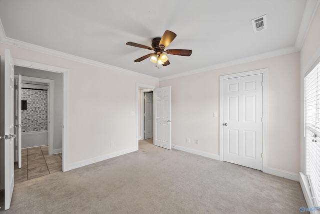 unfurnished bedroom featuring baseboards, carpet flooring, visible vents, and crown molding