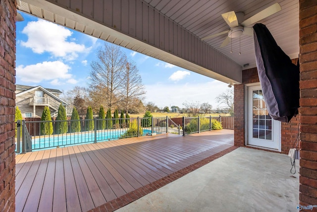 wooden deck featuring a patio area, a fenced in pool, fence, and a ceiling fan