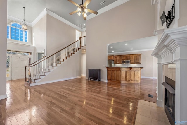 unfurnished living room featuring hardwood / wood-style flooring, stairs, baseboards, and a fireplace