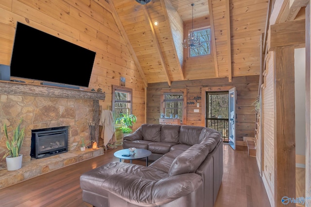 living room with wood ceiling, wooden walls, a fireplace, and wood finished floors
