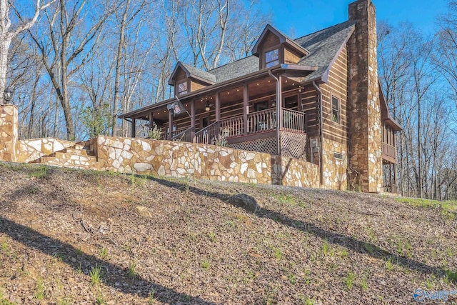 view of side of home featuring a shingled roof and a chimney