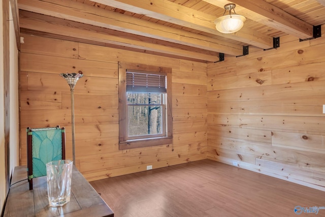 spare room featuring wooden ceiling, wood finished floors, wooden walls, and beamed ceiling