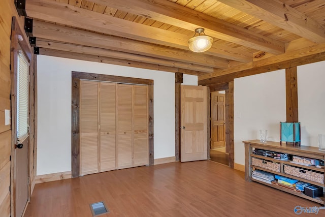 interior space with visible vents, wood finished floors, wood ceiling, and beam ceiling