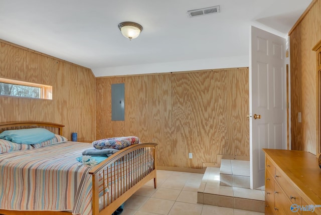 bedroom featuring light tile patterned flooring, visible vents, electric panel, and wood walls