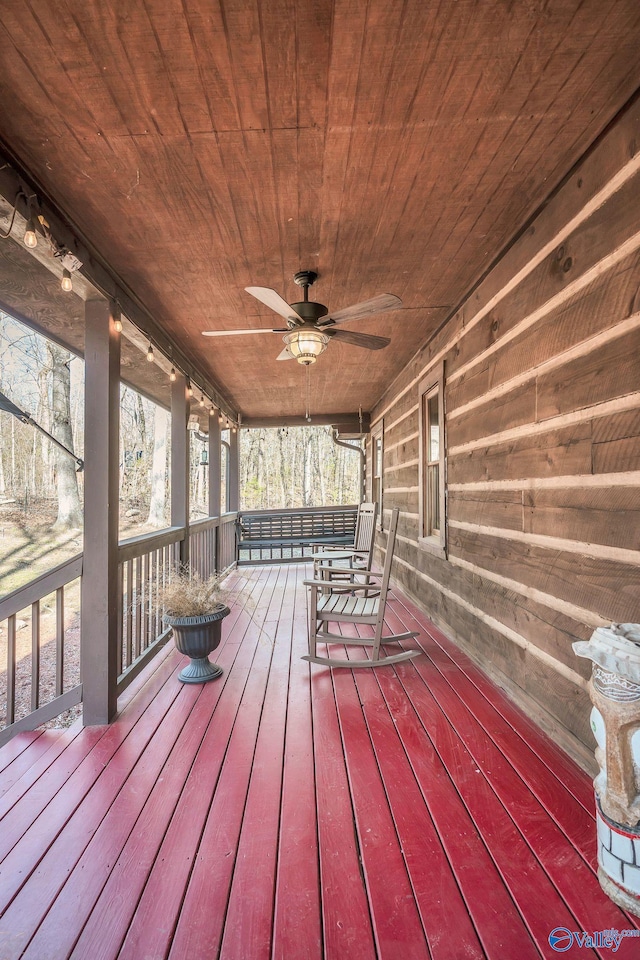 wooden terrace featuring covered porch and a ceiling fan