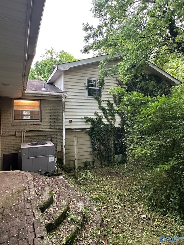exterior space with central air condition unit and brick siding