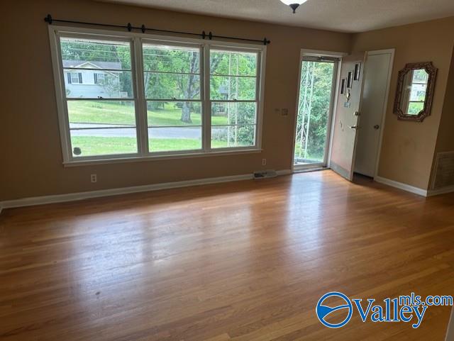 interior space featuring baseboards, wood finished floors, and visible vents